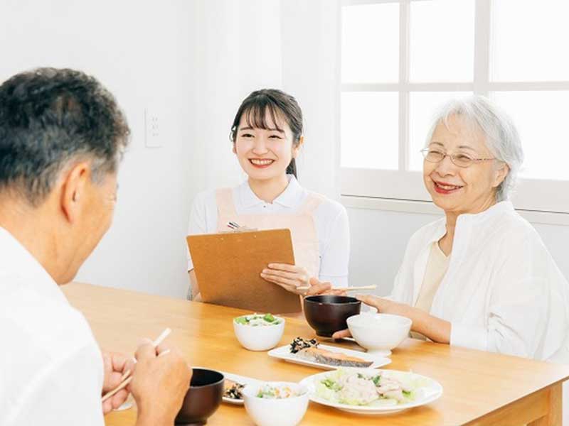 おばあさんと管理栄養士がほほえんでおじいさんを見ている